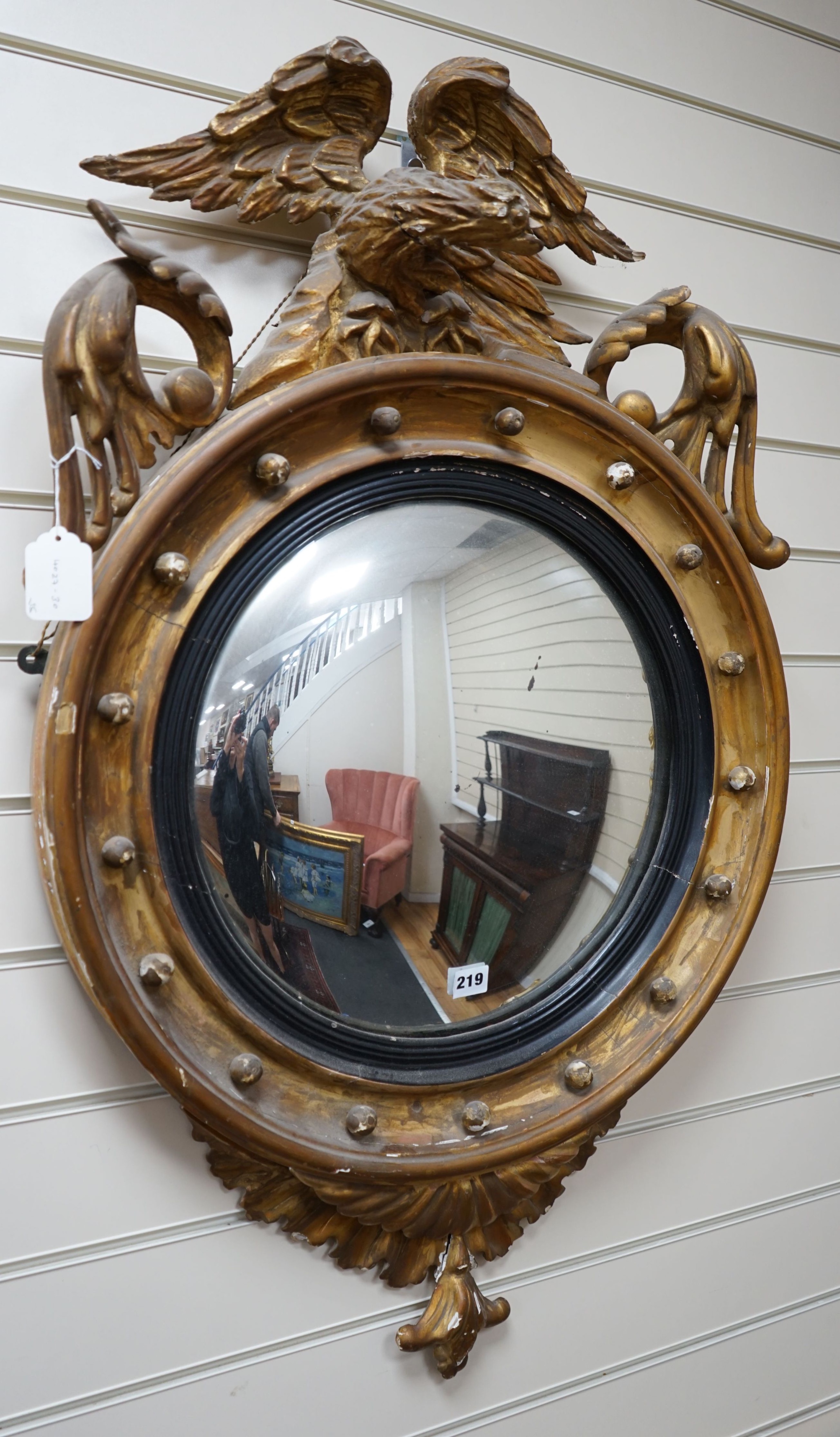 A 19th century gilt and composite circular convex mirror with eagle pediment, width 60cm height 100cm